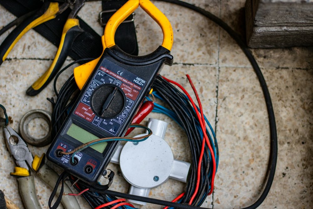 Multímetro y cable eléctrico sobre la mesa de trabajo