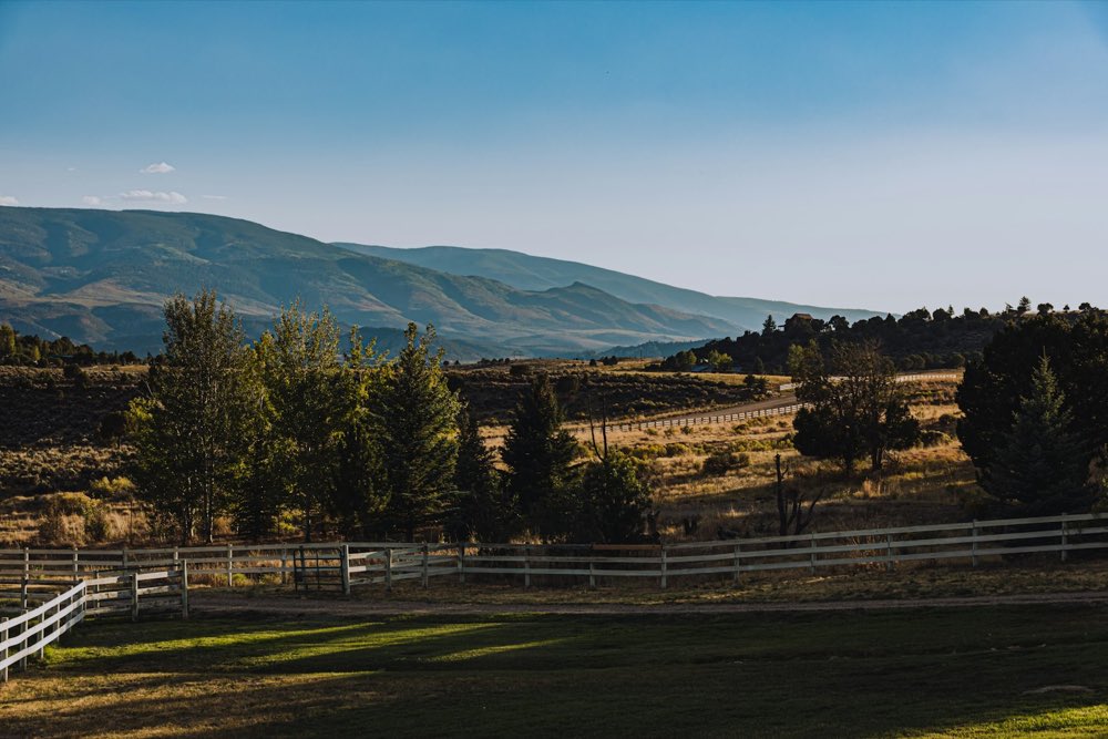 Cerca de madera y potrero con la sierra al fondo