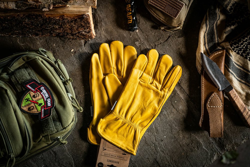 Guantes de trabajo de piel amarilla junto a herramienta